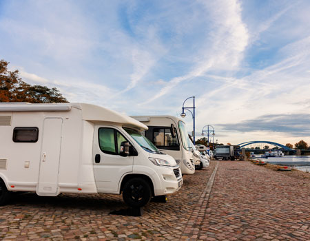 Scenic view of multiple campers and motorhomes parked at a campsite